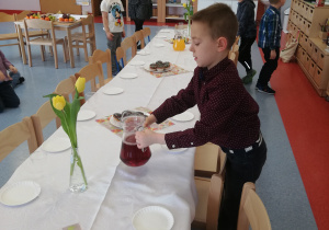 chłopiec kładzie sok na stole